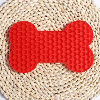 Dog Lick Mat in a bone shape made of black food-grade silicone, perfect for slowing down fast eaters. - Whiskerwise