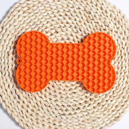 Dog Lick Mat in a bone shape made of black food-grade silicone, perfect for slowing down fast eaters. - Whiskerwise