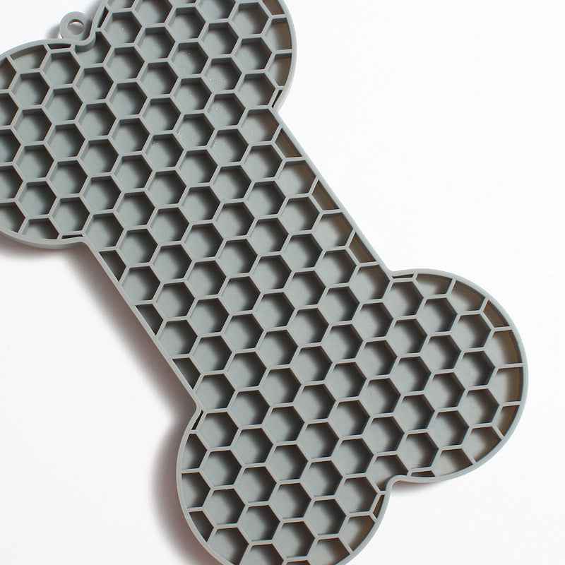 Dog Lick Mat in a bone shape made of black food-grade silicone, perfect for slowing down fast eaters. - Whiskerwise