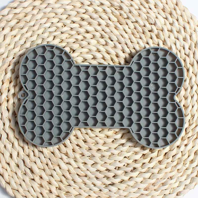 Dog Lick Mat in a bone shape made of black food-grade silicone, perfect for slowing down fast eaters. - Whiskerwise