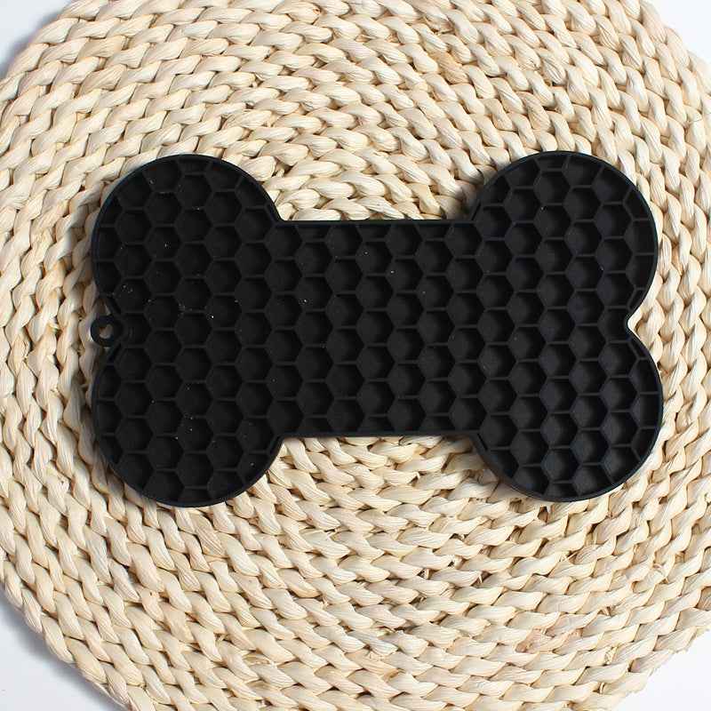 Dog Lick Mat in a bone shape made of black food-grade silicone, perfect for slowing down fast eaters. - Whiskerwise
