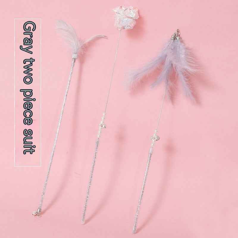 Cat Wand Toy Set – Cat playing with colorful feather on a wand toy while sitting on a chair. - Whiskerwise