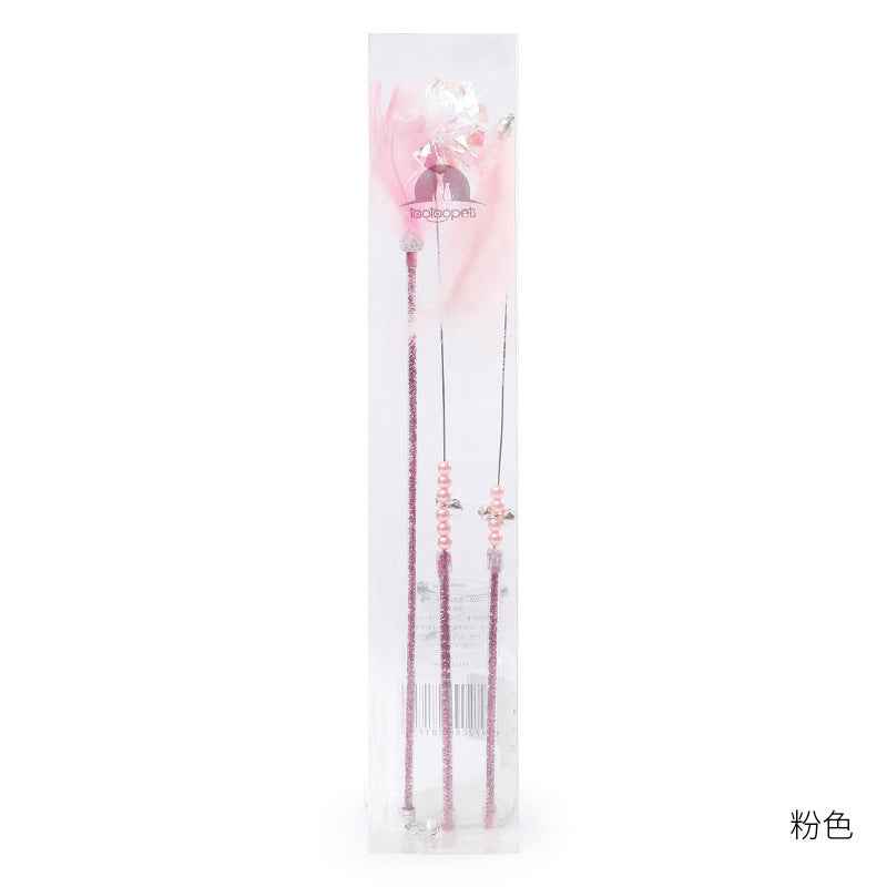 Cat Wand Toy Set – Cat playing with colorful feather on a wand toy while sitting on a chair. - Whiskerwise