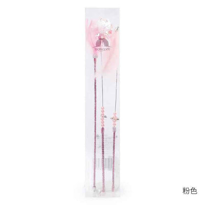 Cat Wand Toy Set – Cat playing with colorful feather on a wand toy while sitting on a chair. - Whiskerwise